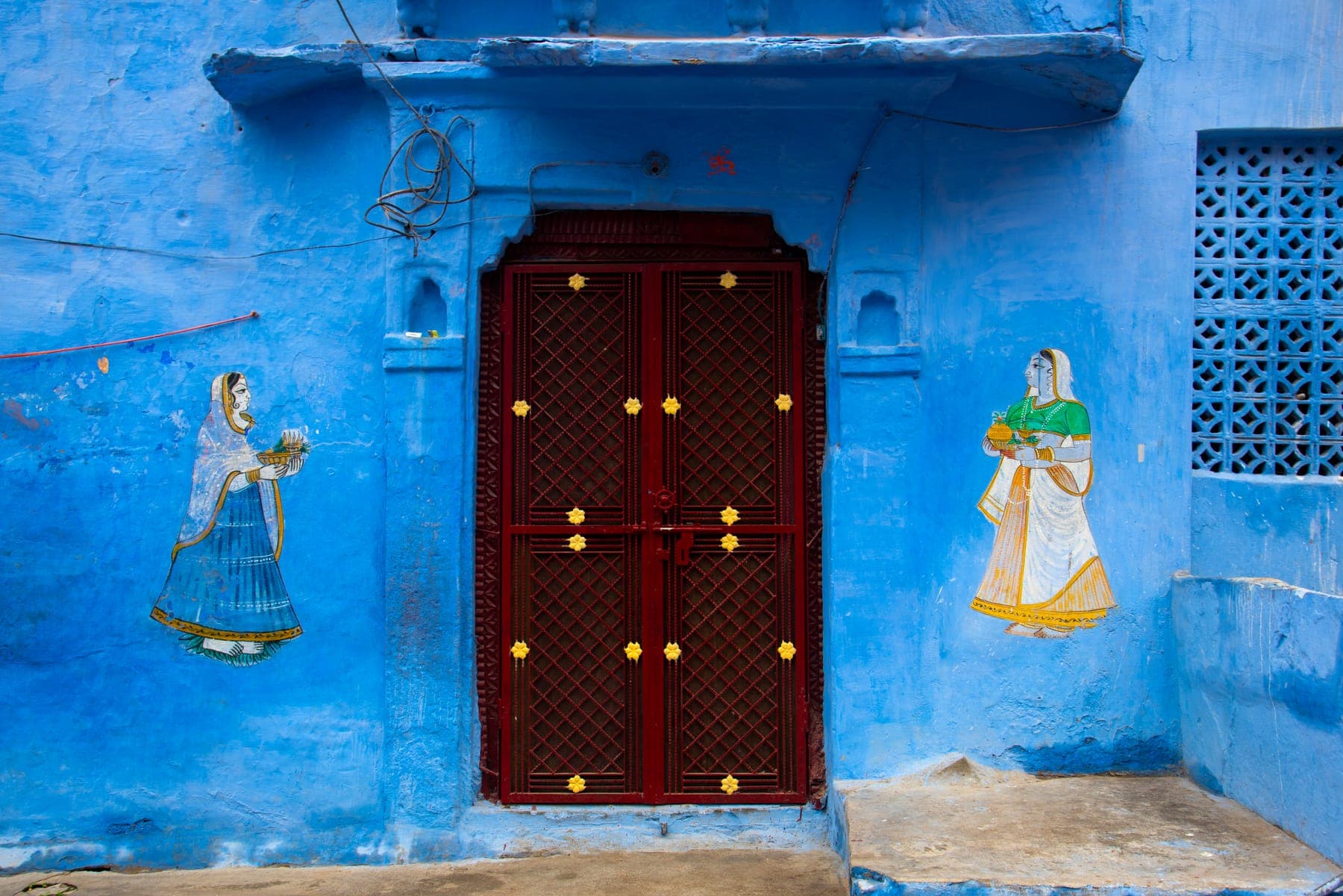 Painted blue wall with a red door in Jodhpur